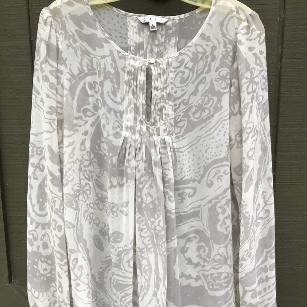 Sheer CAbi pin tucked flows paisley top.